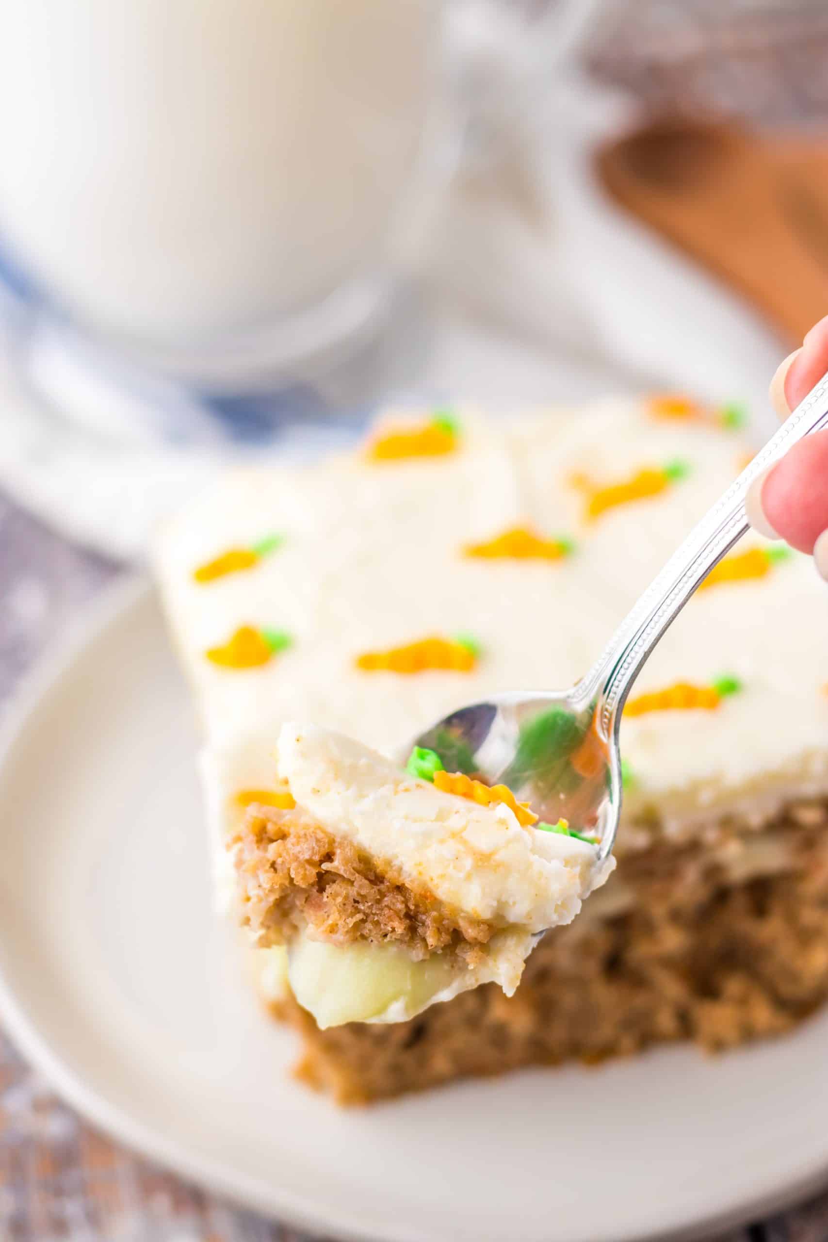 a silver spoon holding up a scoop of carrot cake poke cake
