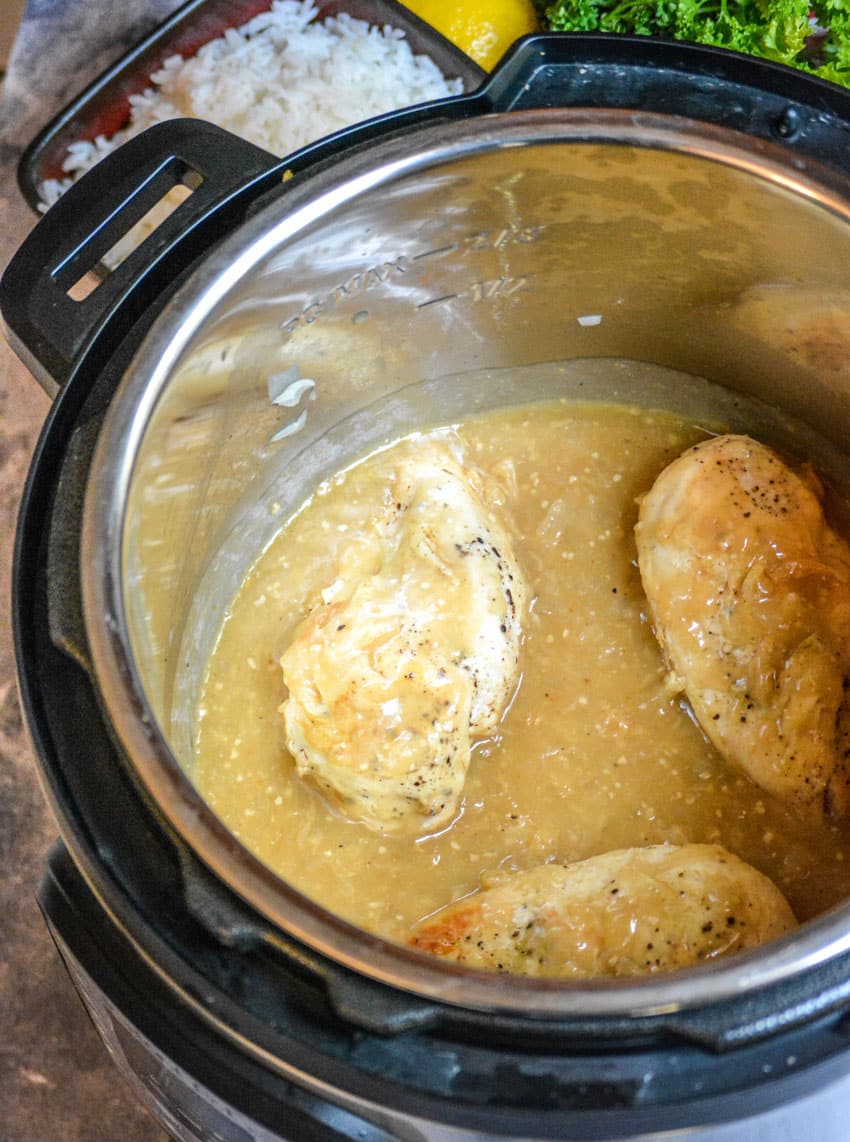 three pieces of lemon chicken in the bowl of an open instant pot pressure cooker
