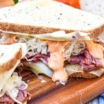 two classic reuben sandwiches on a wooden cutting board