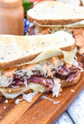 two classic reuben sandwiches on a wooden cutting board