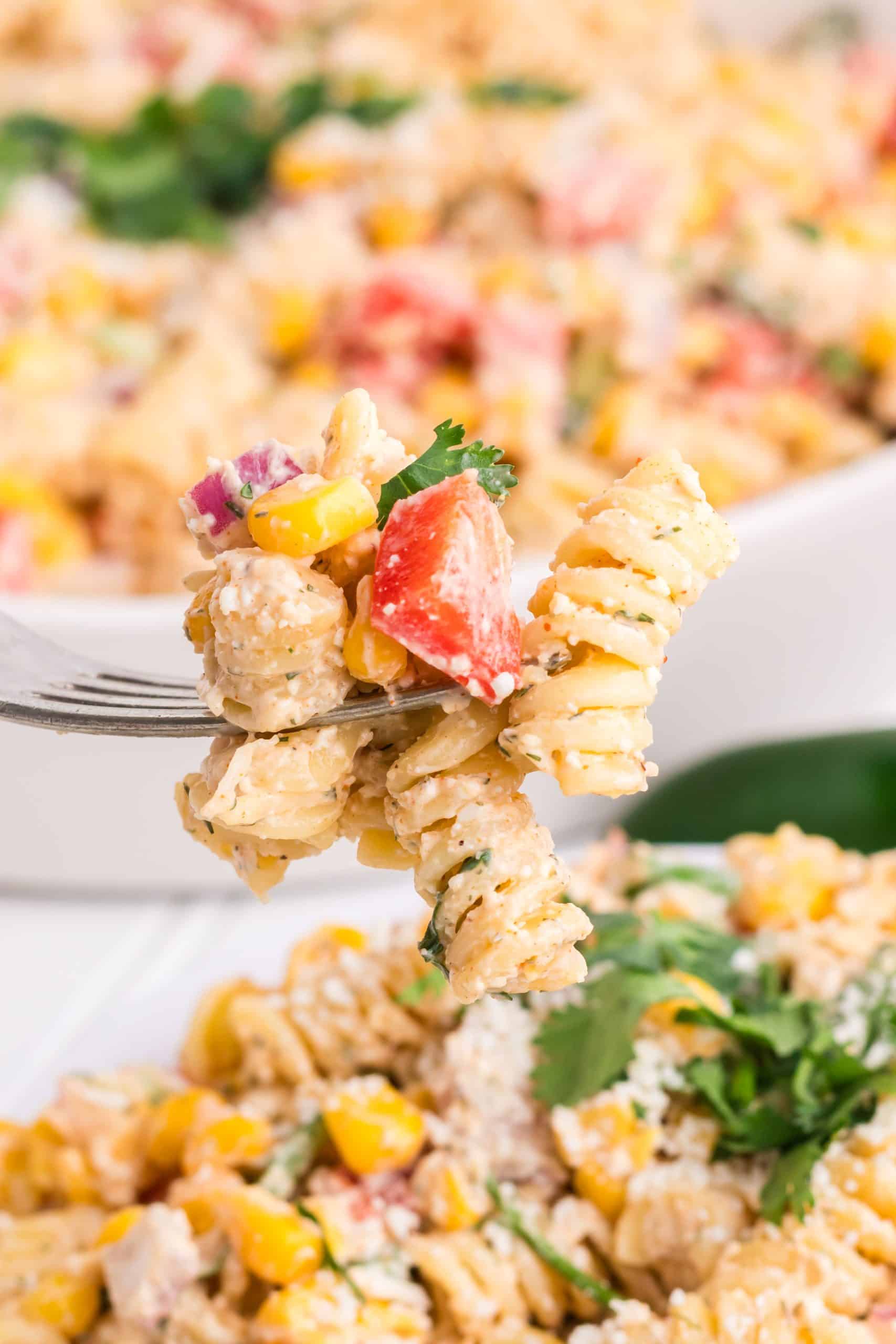 a silver fork holding up a scoop of mexican street corn pasta salad