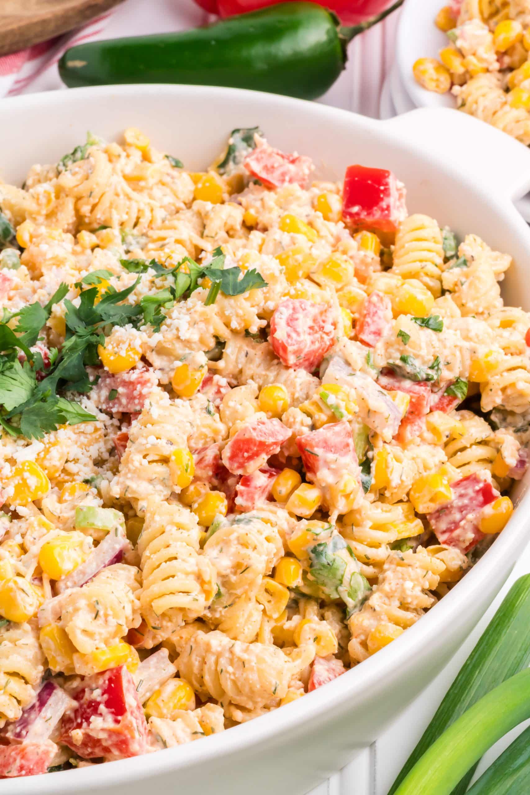 mexican street corn pasta salad in a white serving bowl
