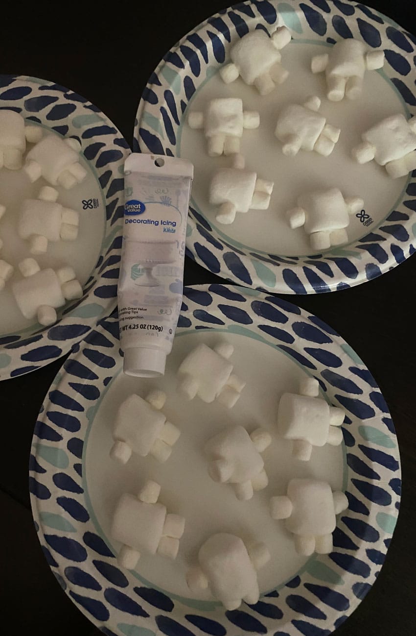 adipose marshmallows on paper plates with a tube of white decorating frosting