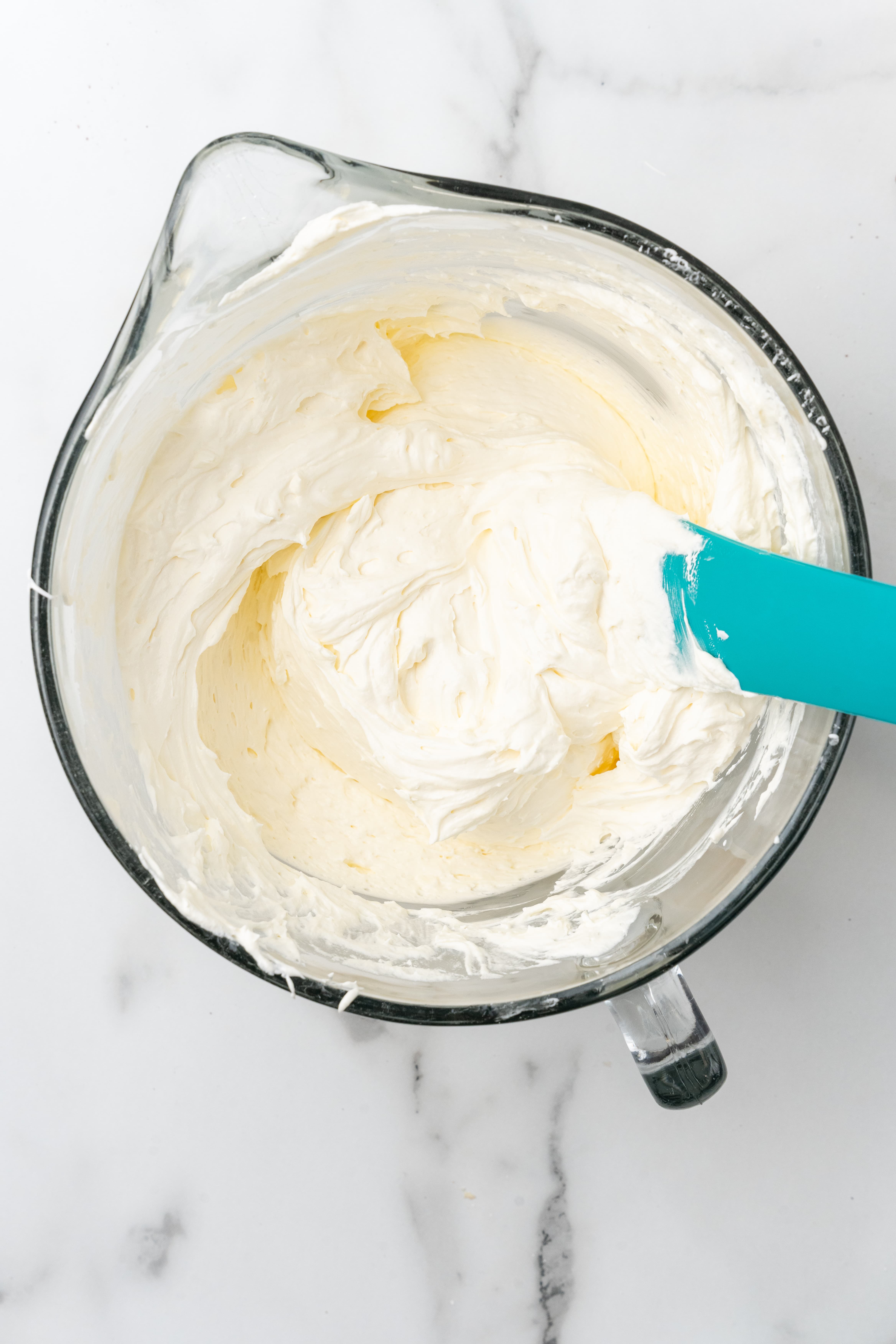 creamy marshmallow fluff in a glass mixing bowl