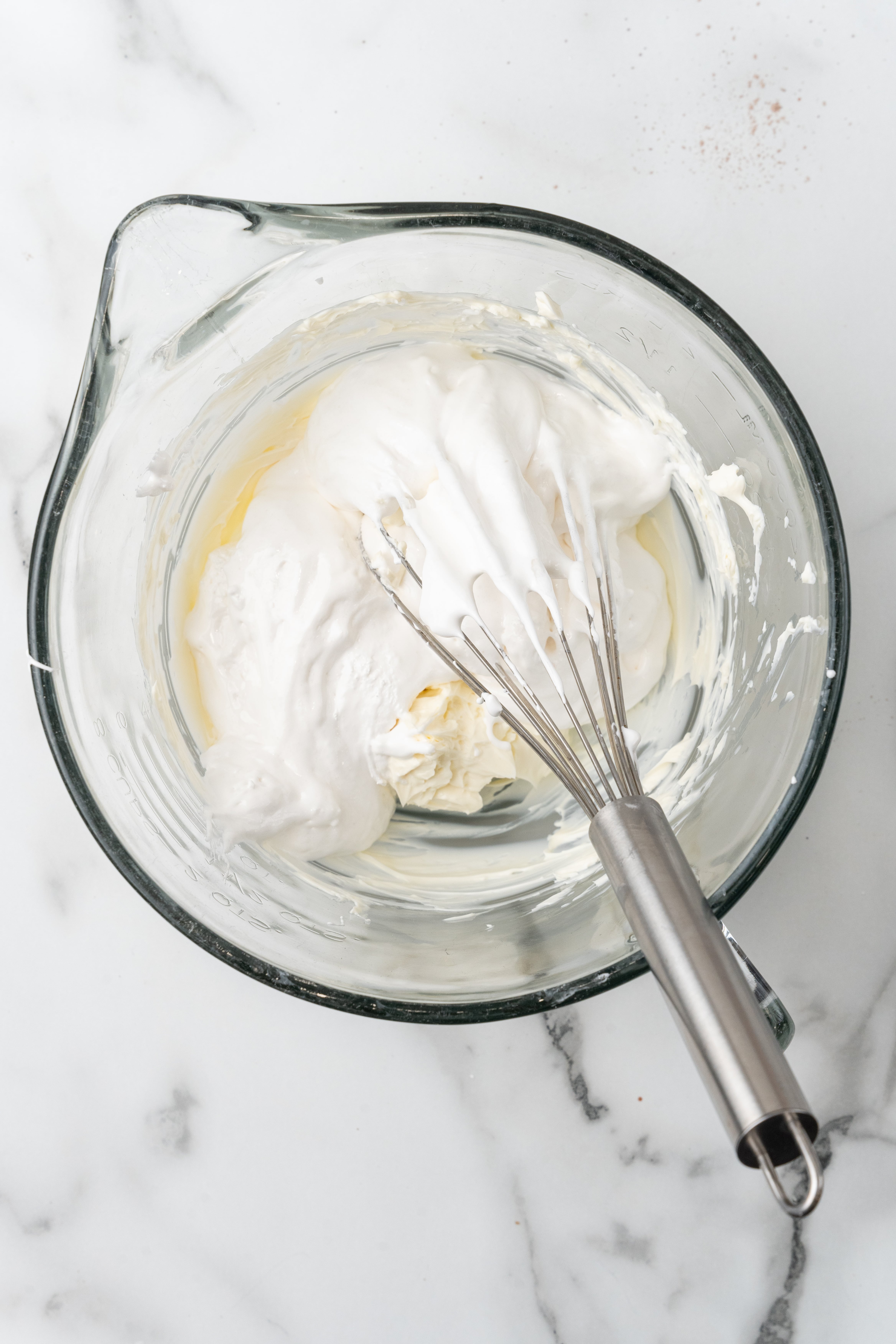 whipped cream cheese and marshmallow fluff in a glass mixing bowl