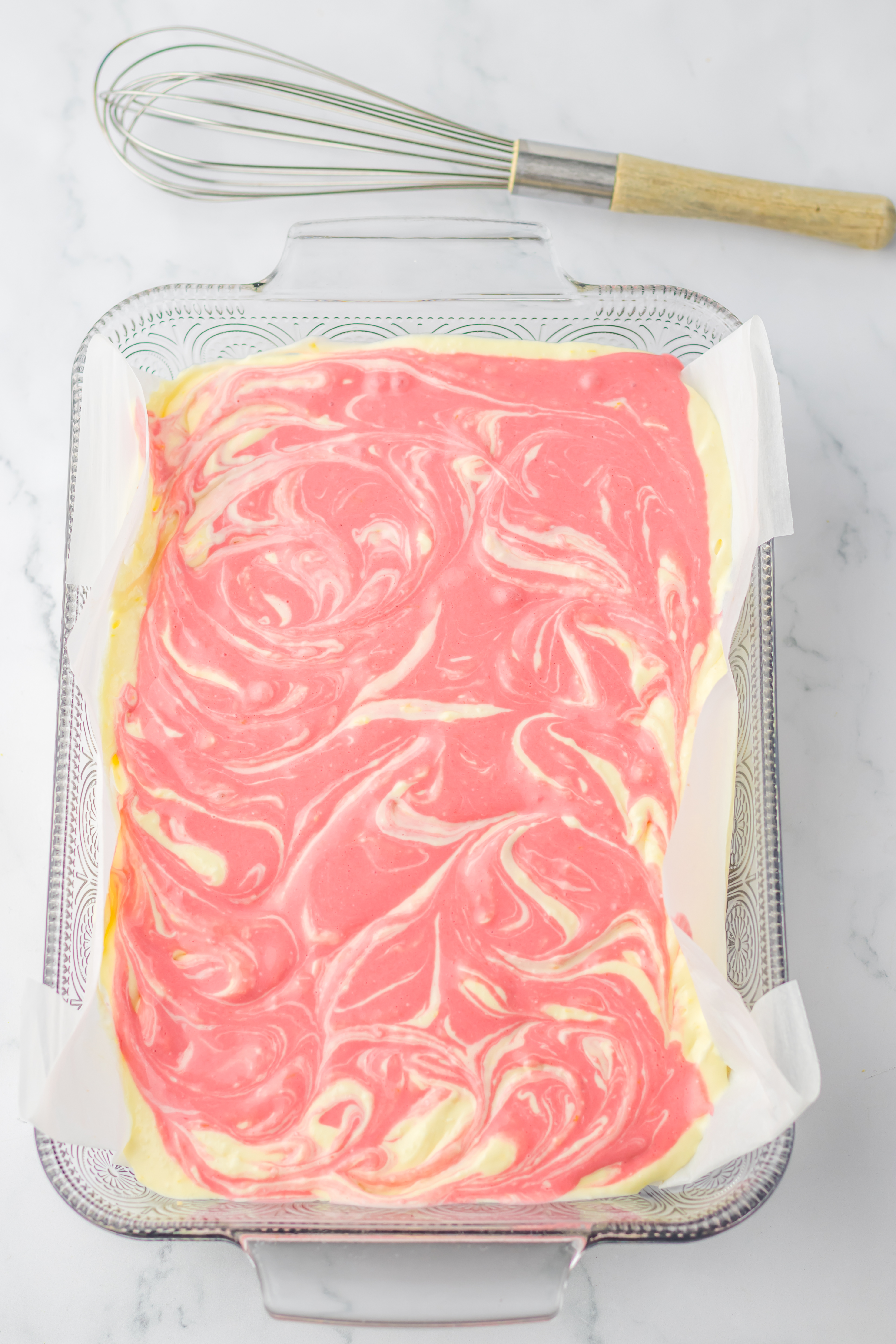 raspberry and vanilla cream cheese filling swirled together in a parchment paper lined baking dish