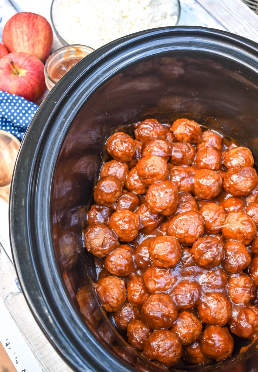 apple butter meatballs in the black bowl of a slow cooker