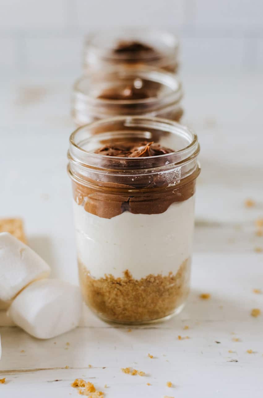 layered s'mores trifles in three small glass jars