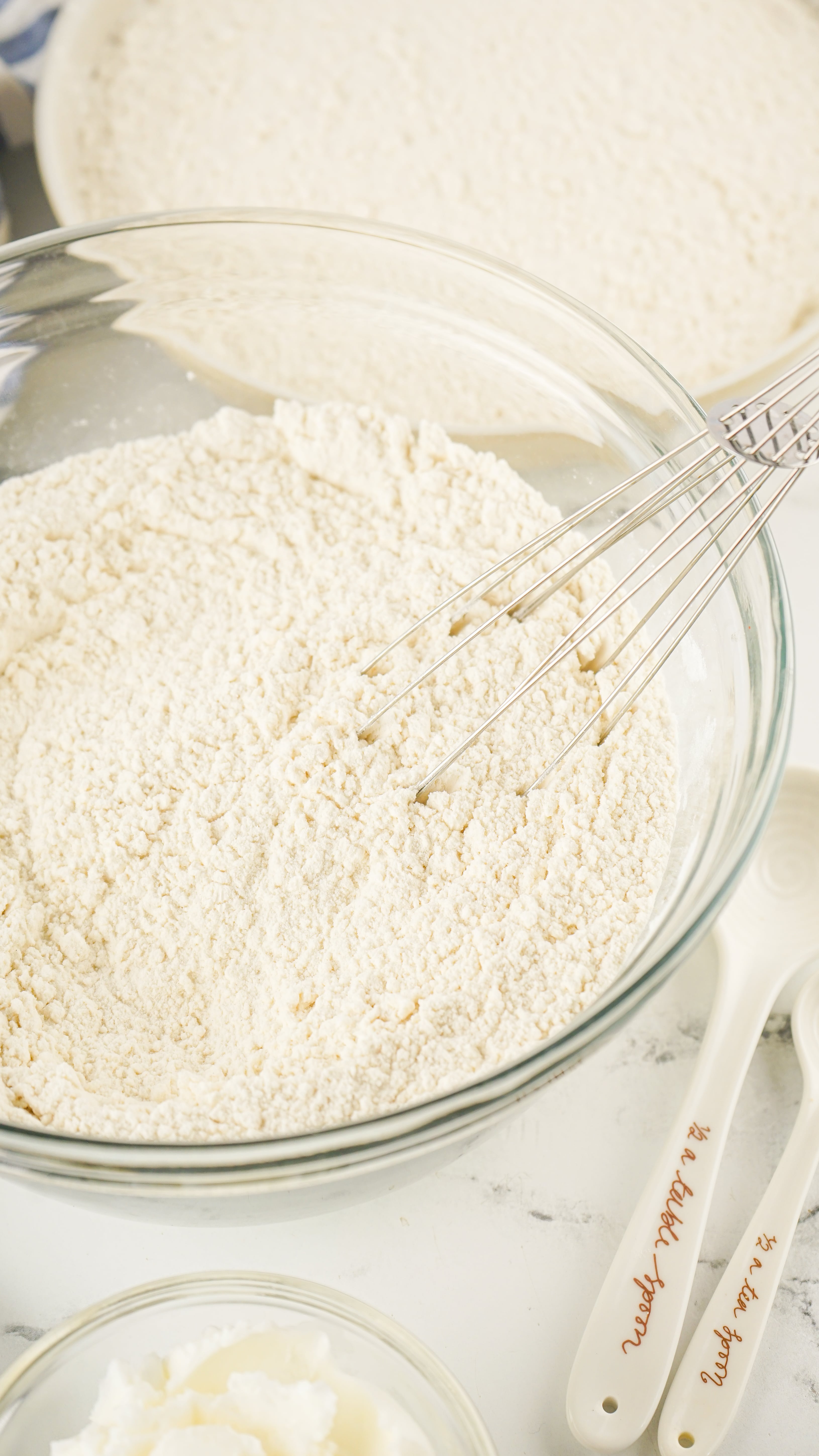 homemade bisquick in a glass mixing bowl with a wire whisk resting on the side