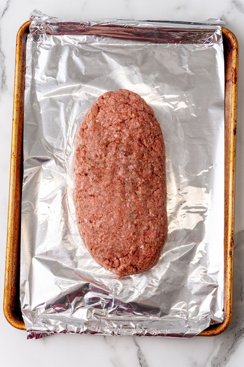 unbaked meatloaf resting on a foil lined baking sheet