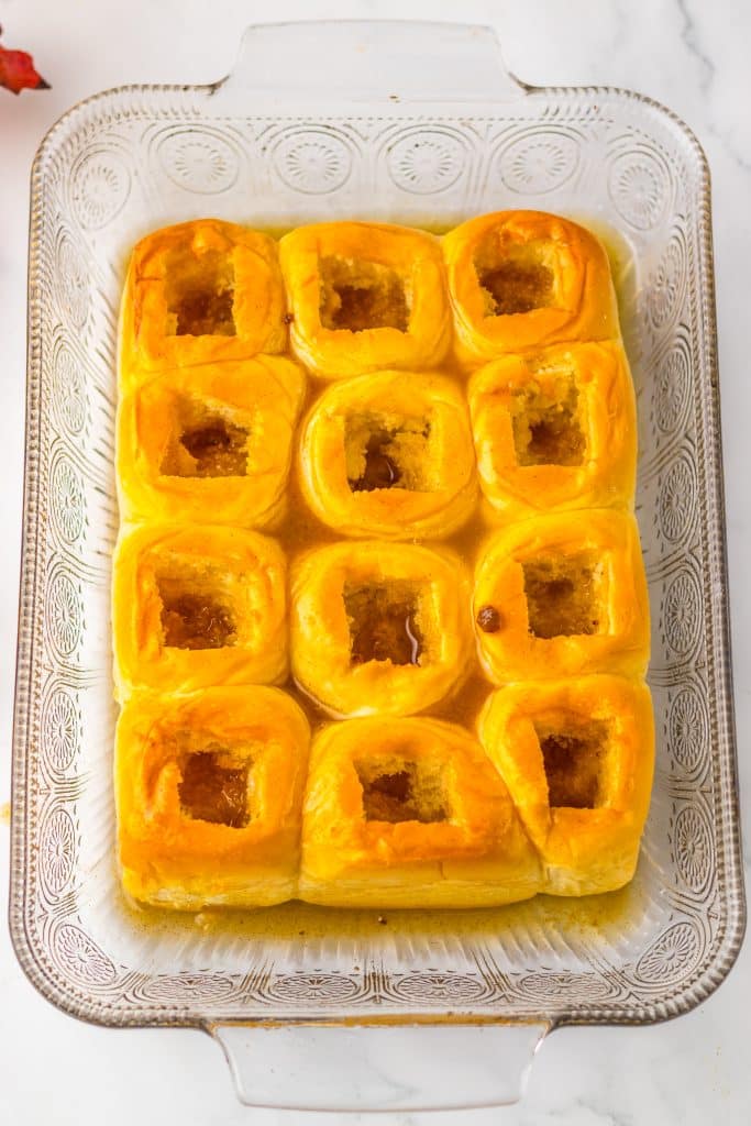 sweet hawaiian rolls with holes cut in the center in a glass casserole dish