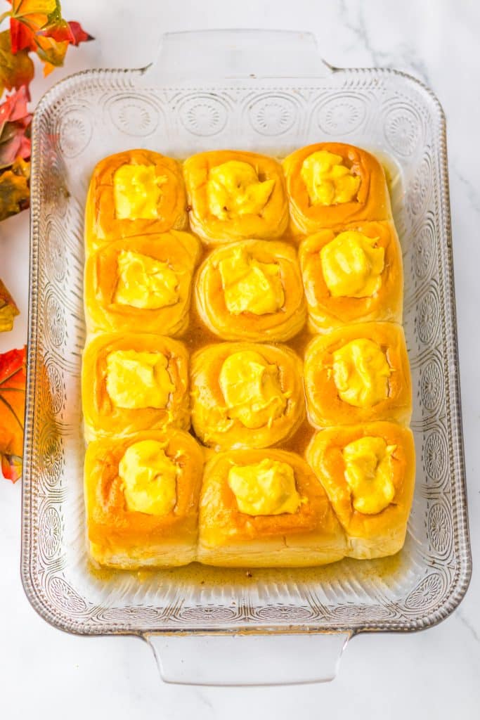 pumpkin cream cheese filled hawaiian rolls in a glass baking dish