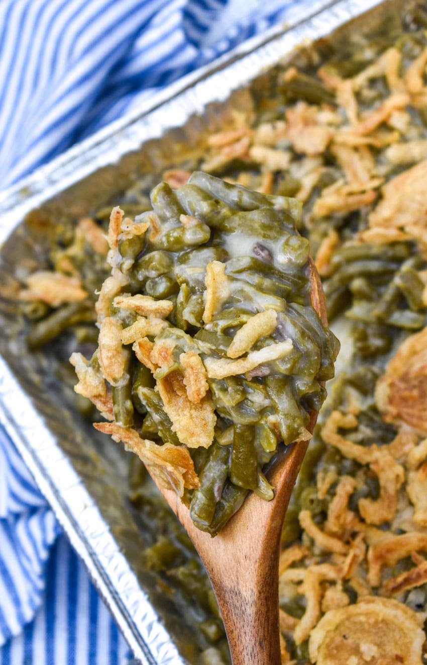 a wooden spoon holding up a scoop of smoked green bean casserole