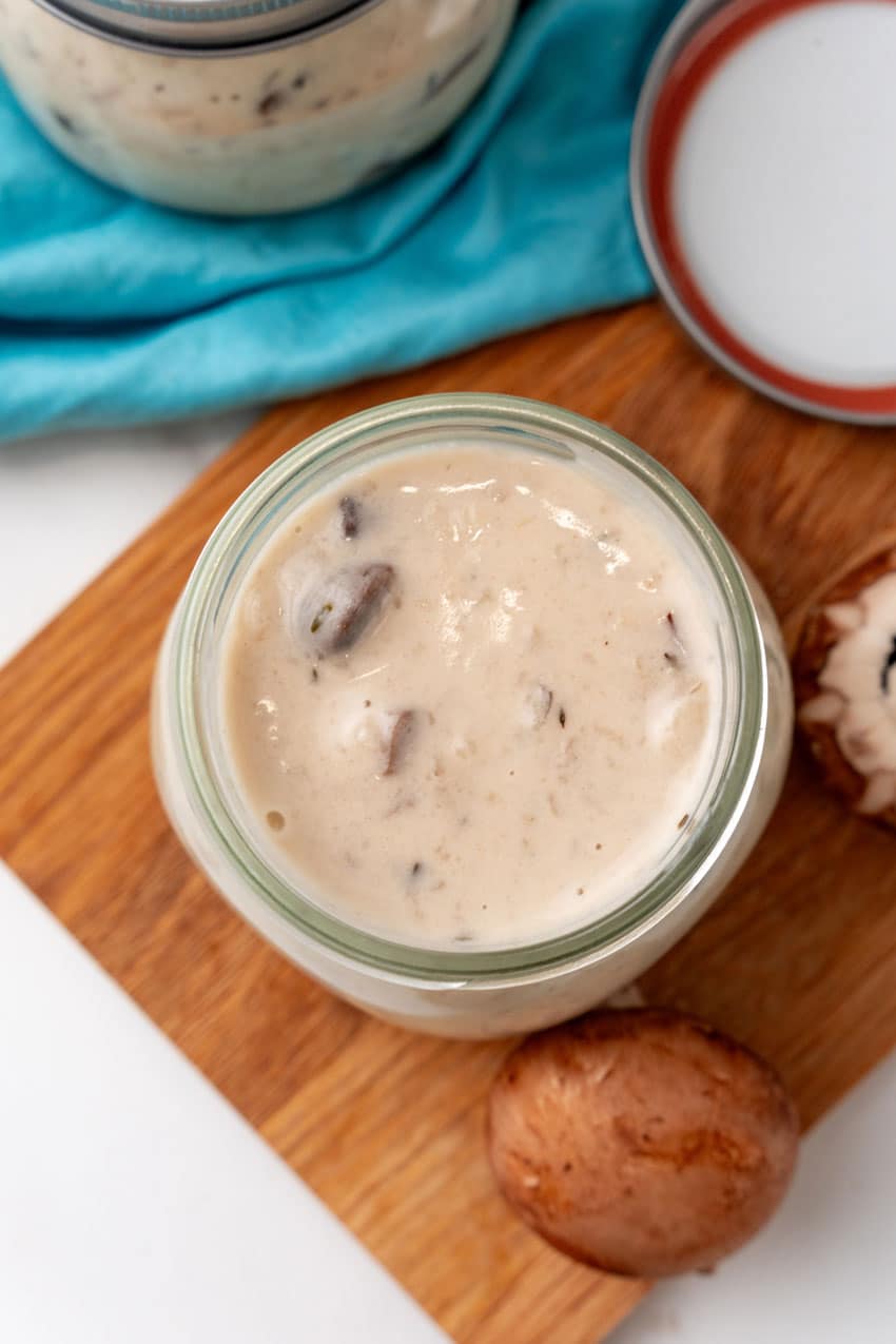 an overhead image showing homemade cream of mushroom soup in a glass jar