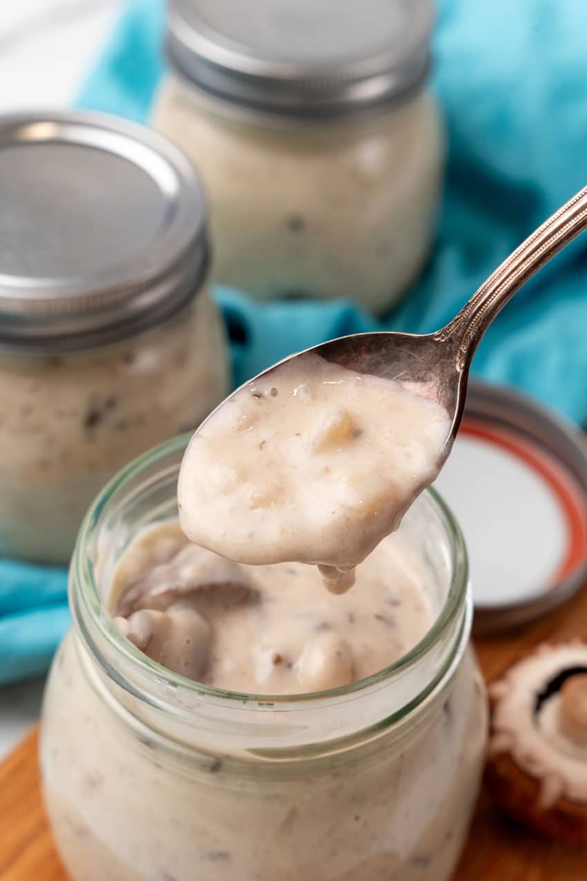 homemade cream of mushroom soup in a glass jar on a wooden cutting board