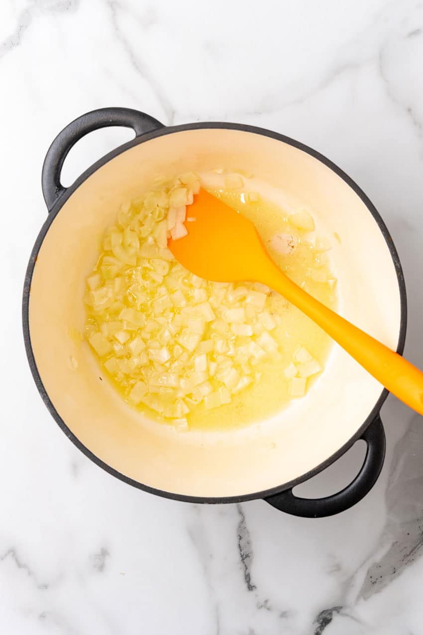 onions sauteeing in butter in a large dutch oven