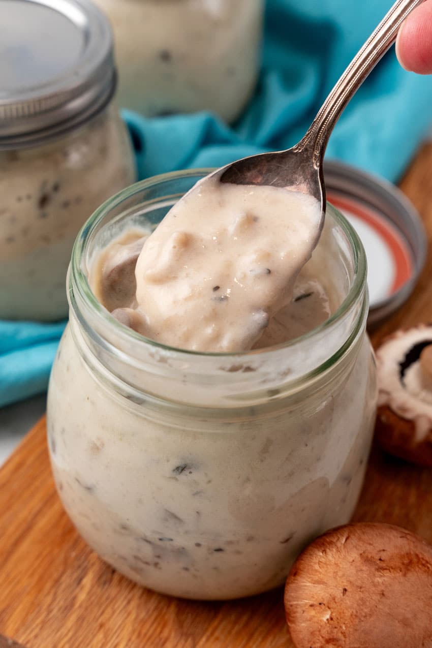 homemade cream of mushroom soup in a glass jar on a wooden cutting board