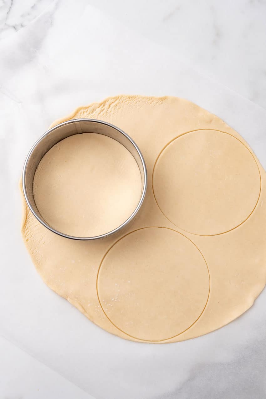 a cookie cutter cutting circles out of pie crust