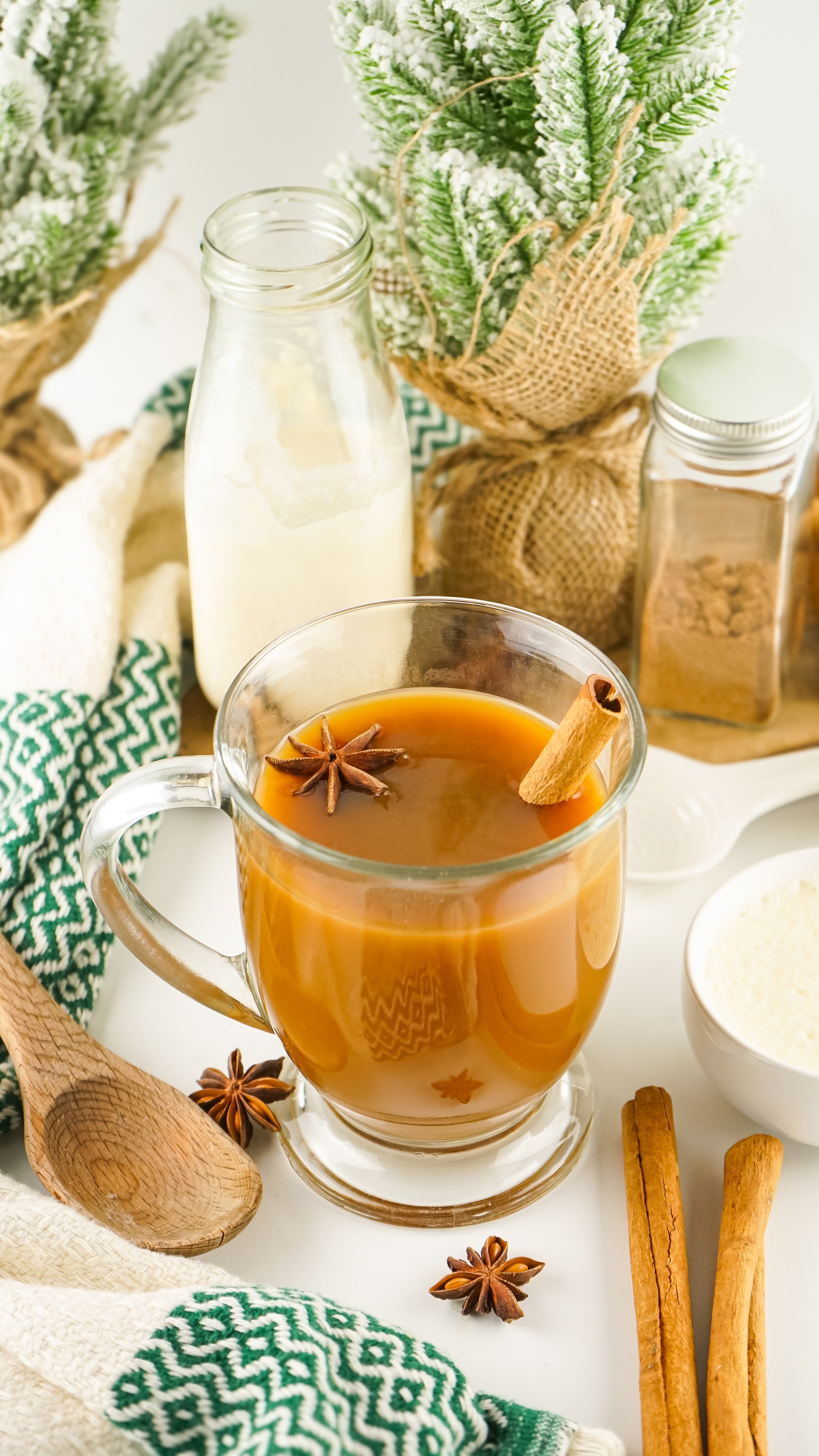 eggnog coffee creamer flavored coffee in a glass mug with a cinnamon stick and star anise floating for a garnish