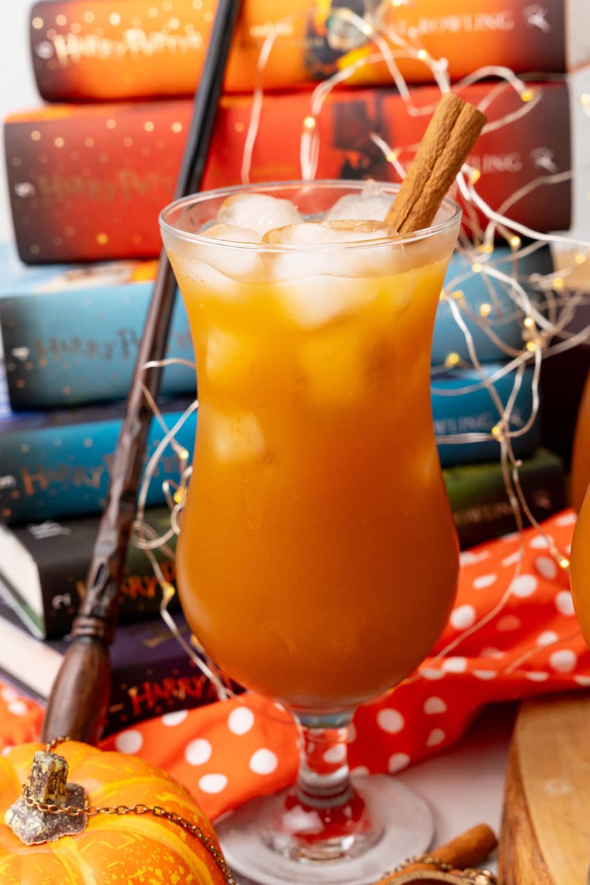 harry potter pumpkin juice in two glasses with ice cubes and cinnamon sticks as a garnish