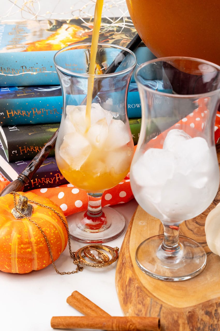 harry potter pumpkin juice being poured into a tall glass over ice