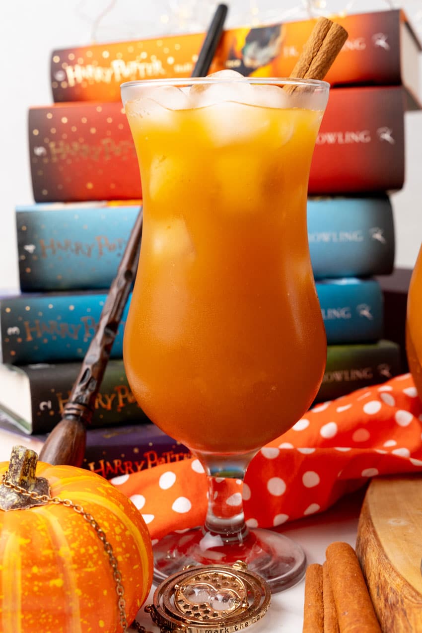 harry potter pumpkin juice in two glasses with ice cubes and cinnamon sticks as a garnish