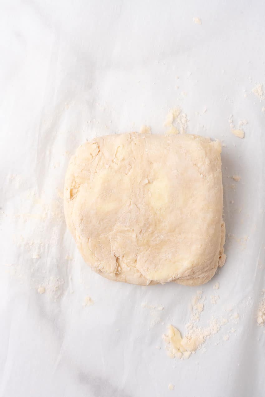 folded sheet of homemade puff pastry dough on a floured piece of parchment paper