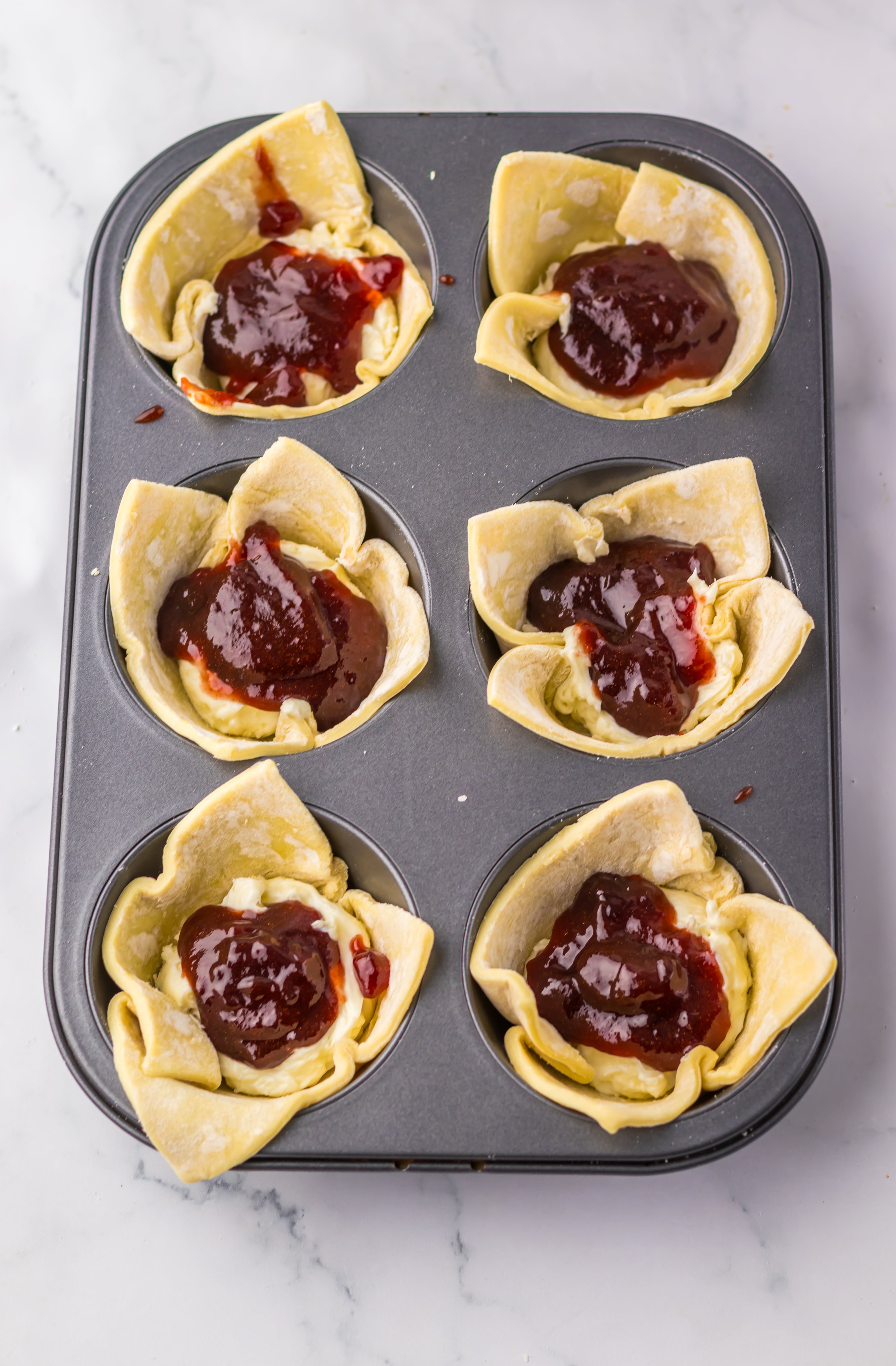 unbaked sugar plum danishes in a jumbo metal muffin tin