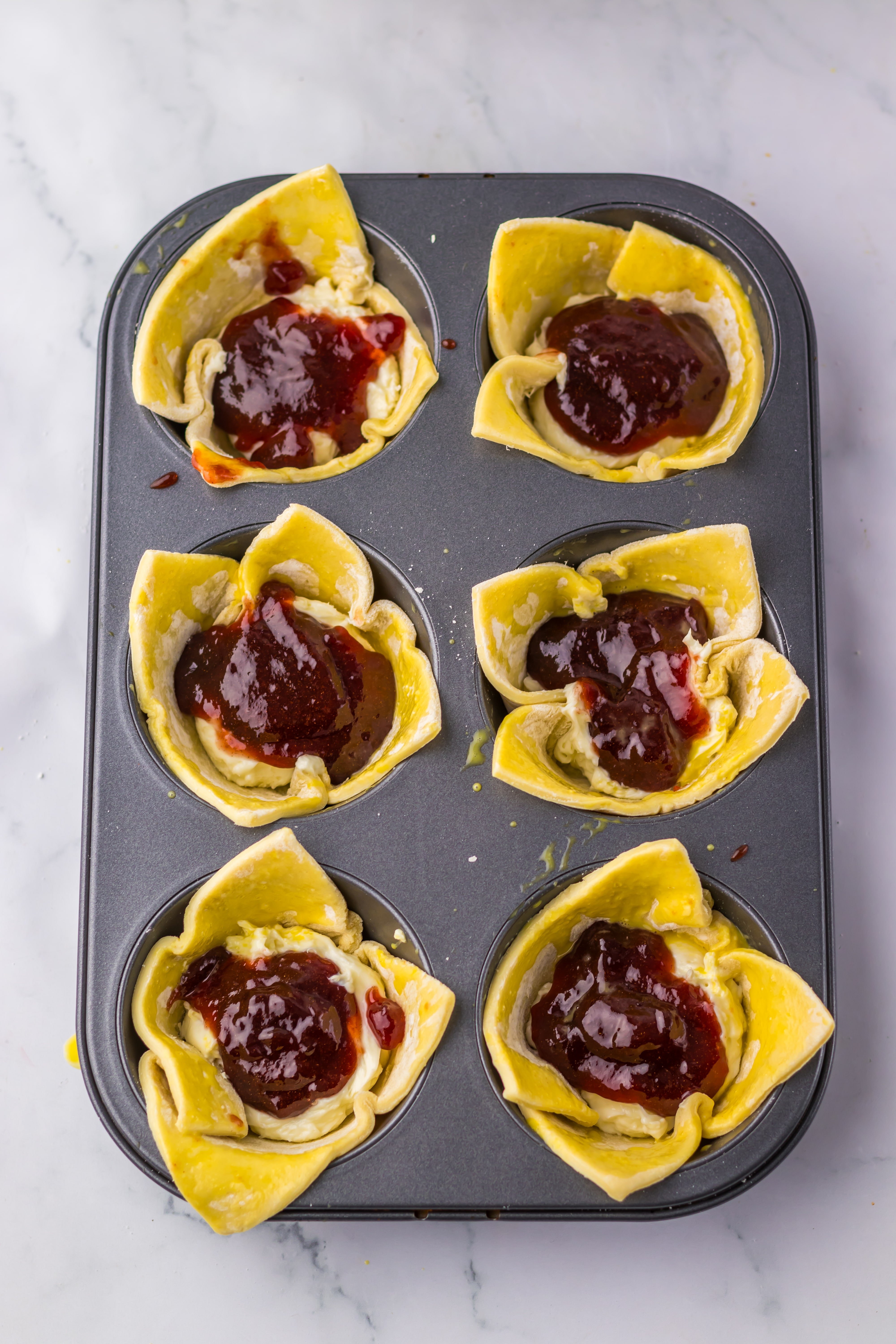 unbaked sugar plum danishes in a jumbo metal muffin tin