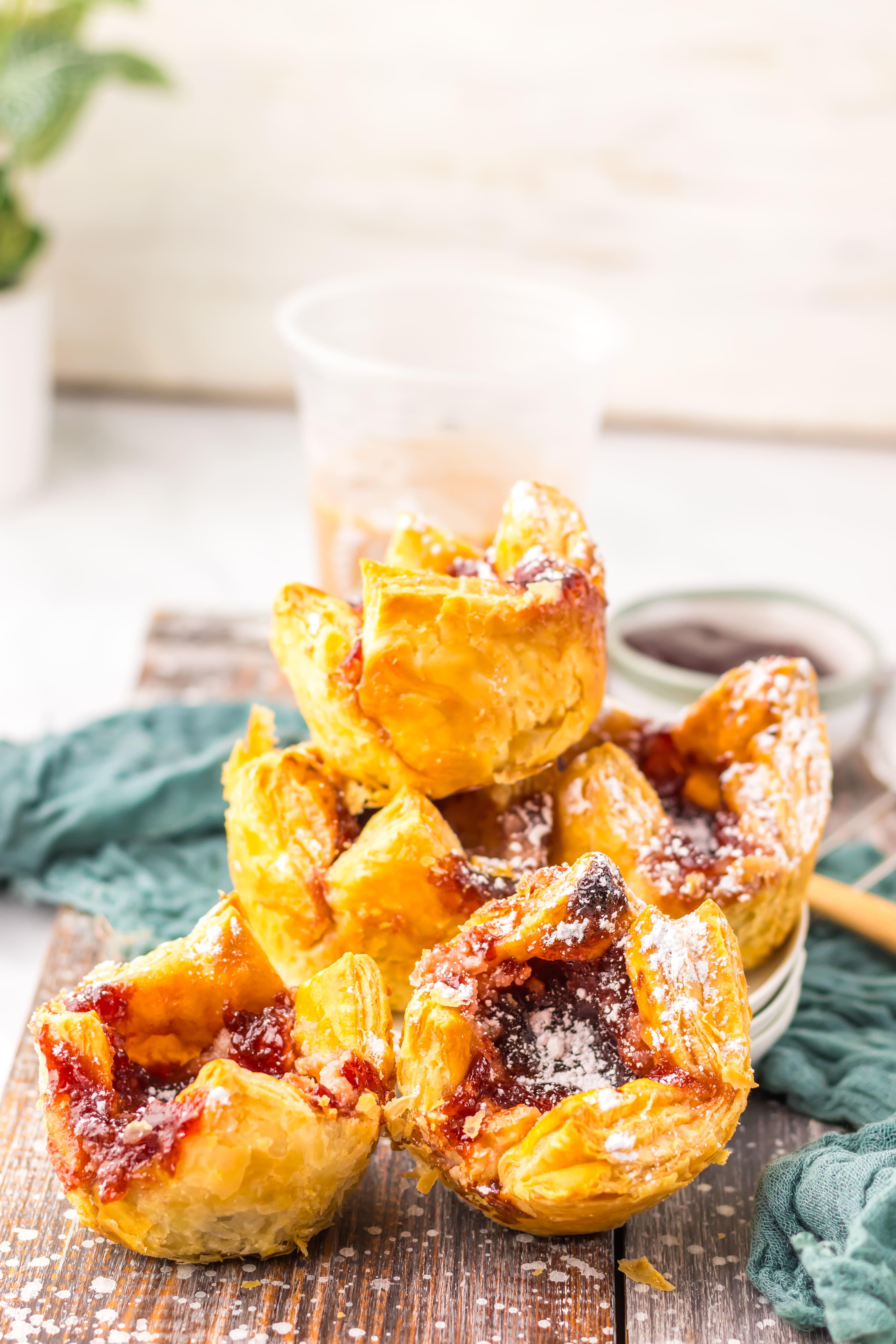 powdered sugar sprinkled sugar plum danishes on a wooden table