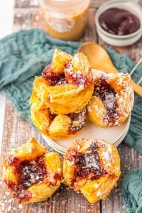 powdered sugar sprinkled sugar plum danishes on a wooden table