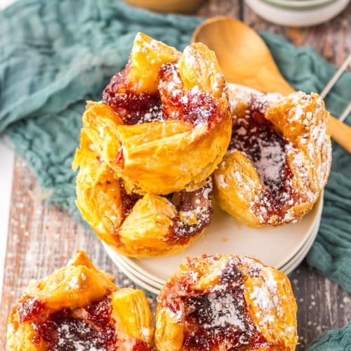 powdered sugar sprinkled sugar plum danishes on a wooden table