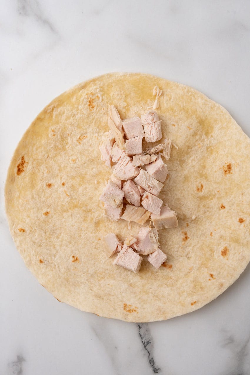 diced turkey in the center of a large flour tortilla