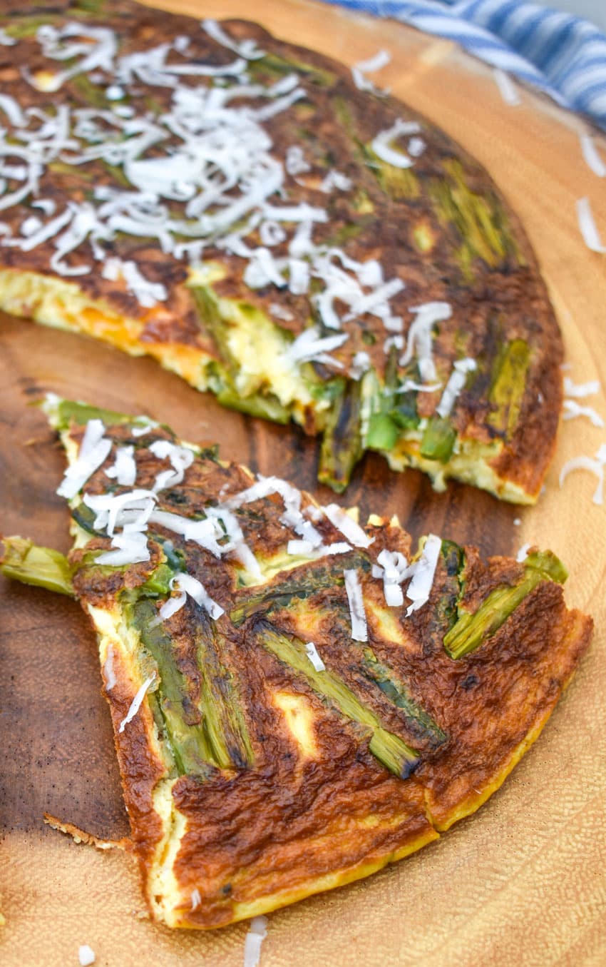 slices of cheddar asparagus frittata on a wooden cutting board