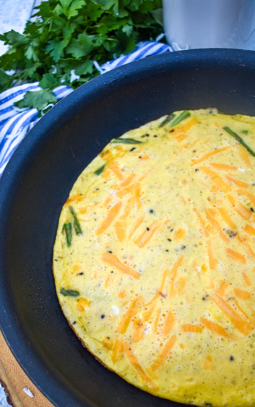 a cheddar asparagus frittata in a small black skillet