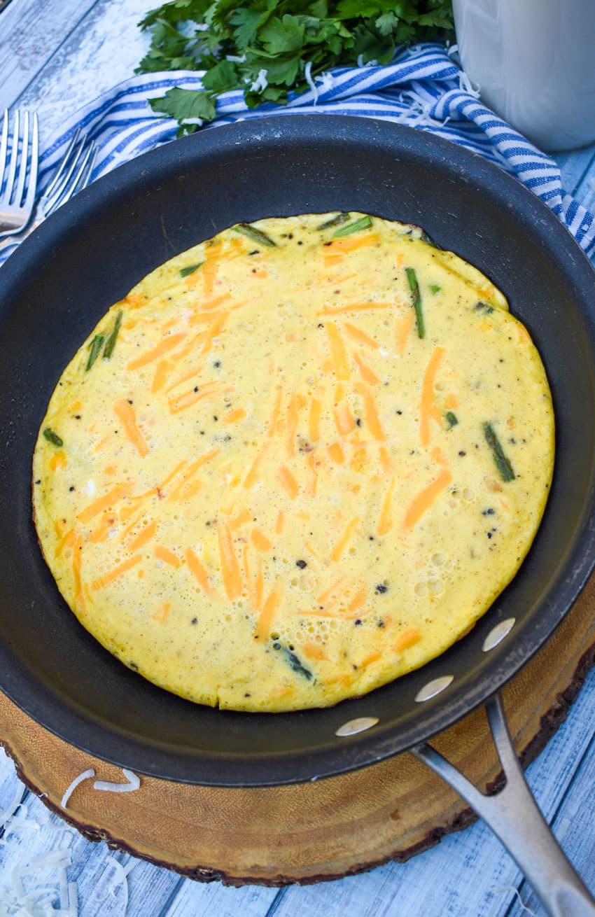 a cheddar asparagus frittata in a small black skillet