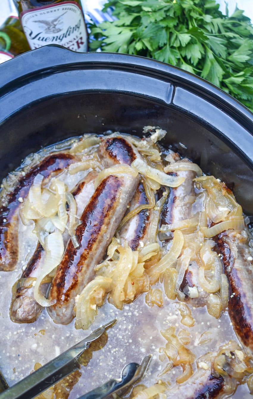 bratwurst and sauerkraut in the black crock of a slow cooker