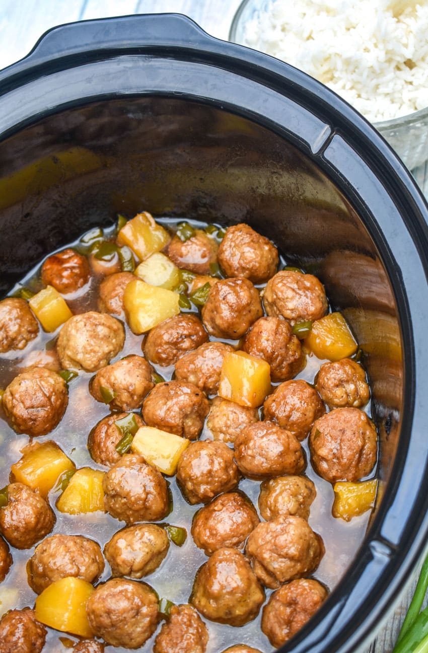 slow cooker hawaiian meatballs in a black crock