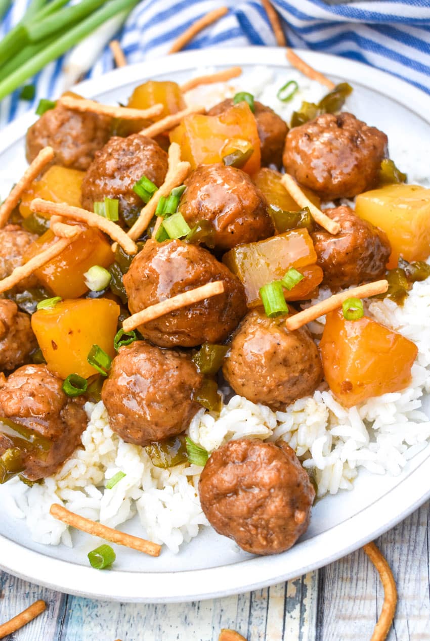 crockpot hawaiian meatballs over steamed white rice on a white dinner plate