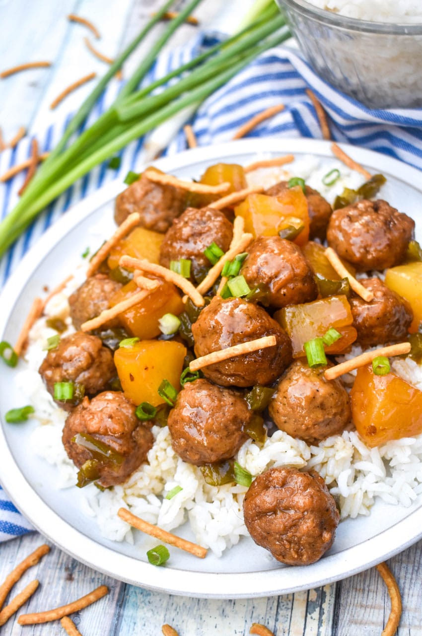 crockpot hawaiian meatballs over steamed white rice on a white dinner plate