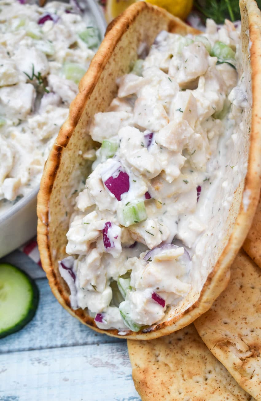 a white pita bread wrapped around tzatziki chicken salad