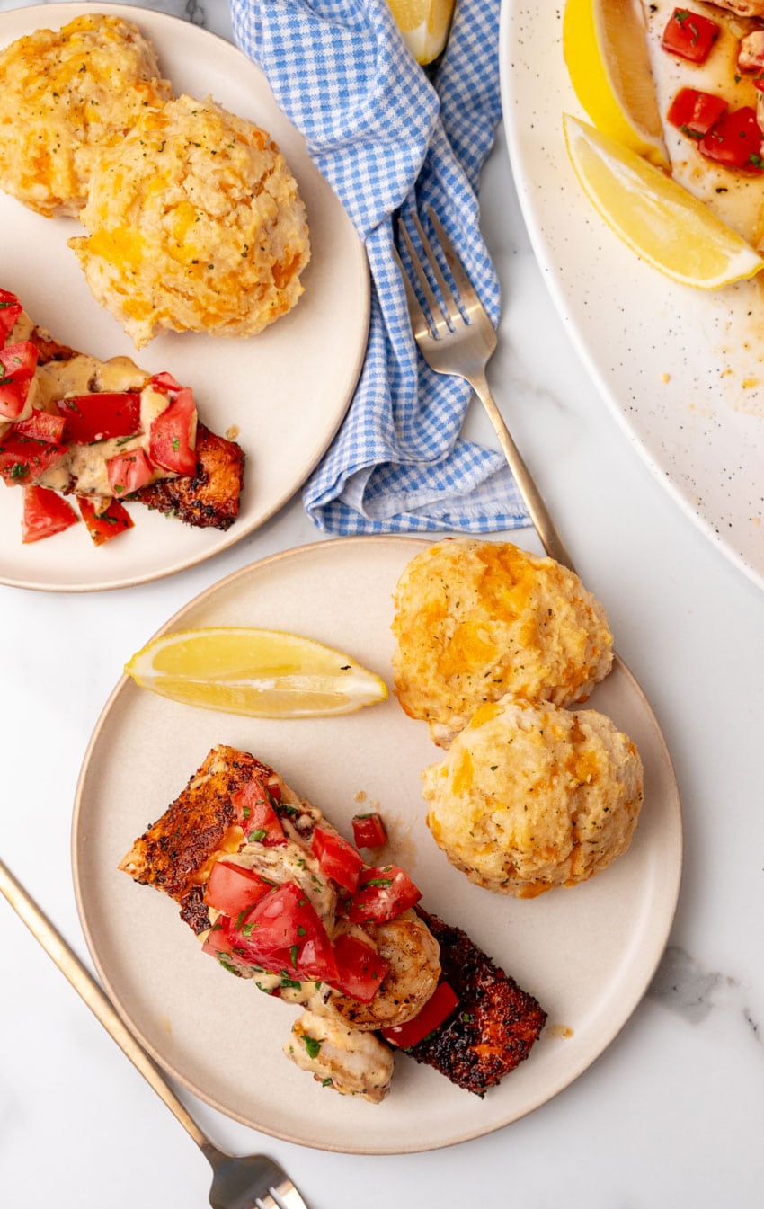 red lobster copycat slices of salmon new orleans served on small white plates with lemon wedges and cheddar bay biscuits on the side