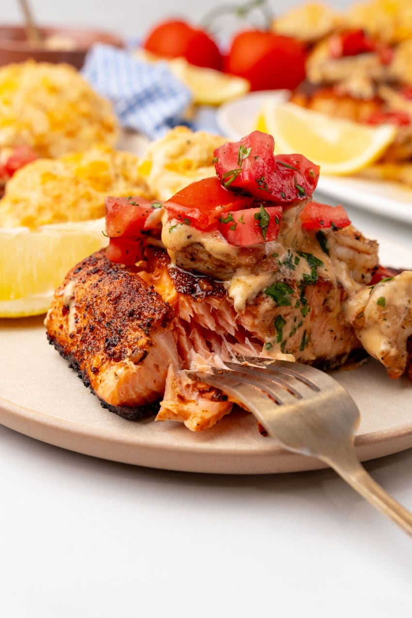 copycat red lobster salmon new orleans on a small white plate with cheddar bay biscuits on the side