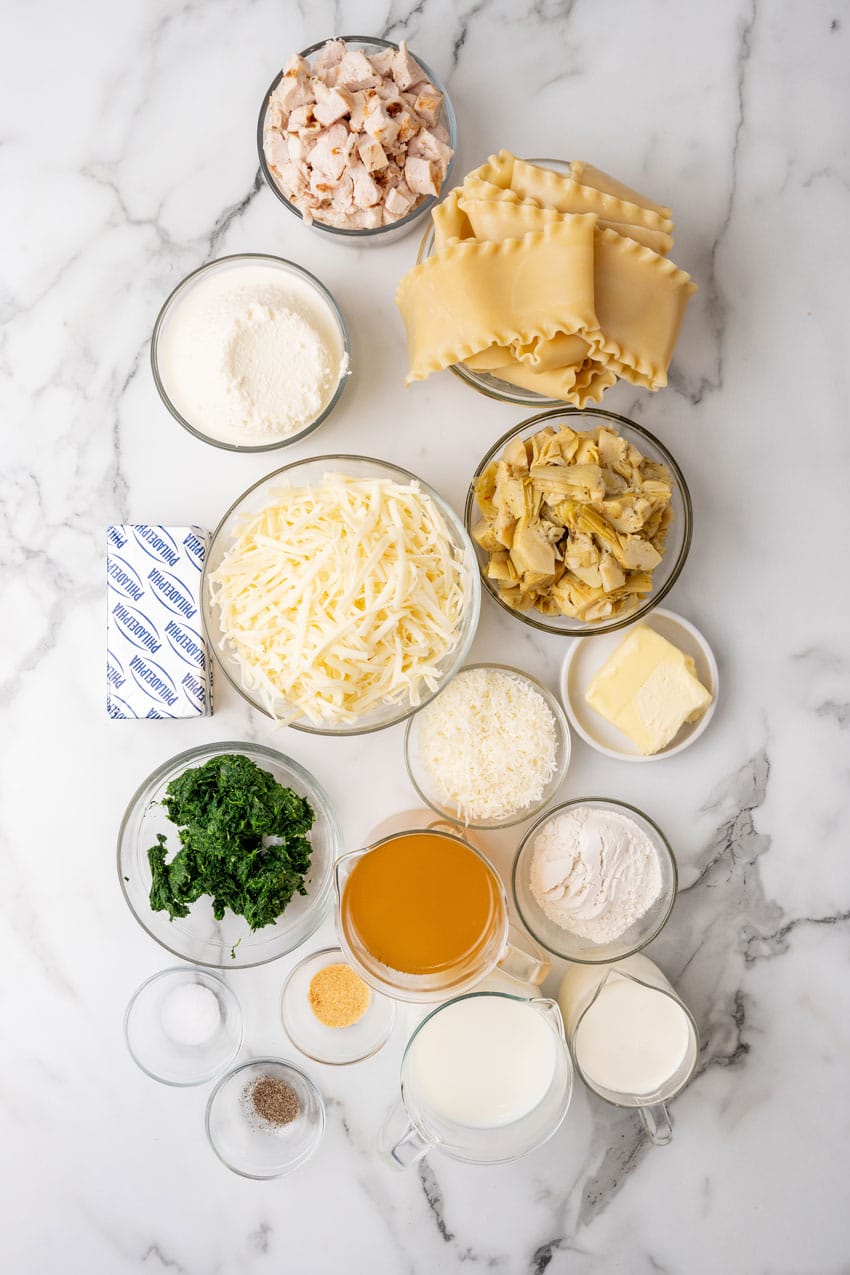 an overhead image showing the measured ingredients needed to make a spinach and artichoke lasagna