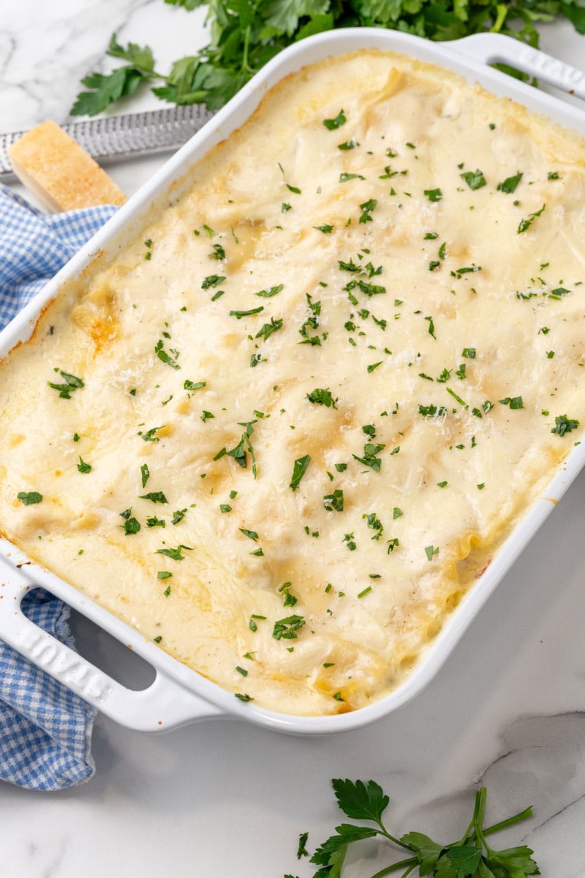 spinach artichoke lasagna in a white baking dish