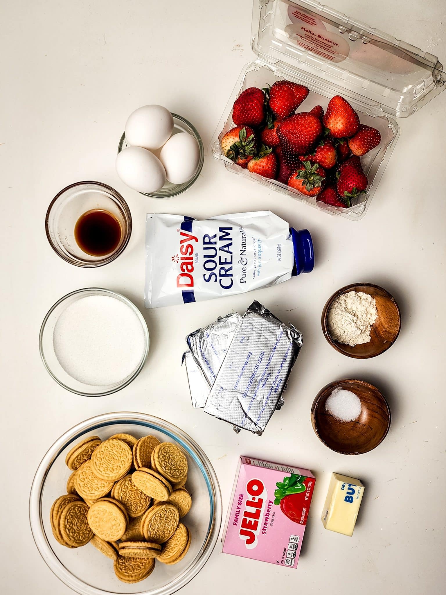 an overhead image showing the measured ingredients needed to make a strawberry crunch cheesecake