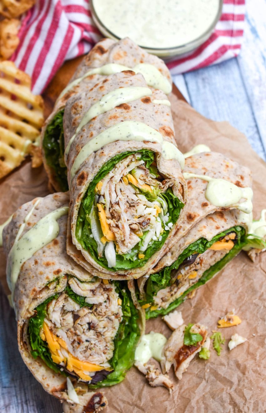 chick fil a chicken cool wraps cut in half and stacked on brown parchment paper