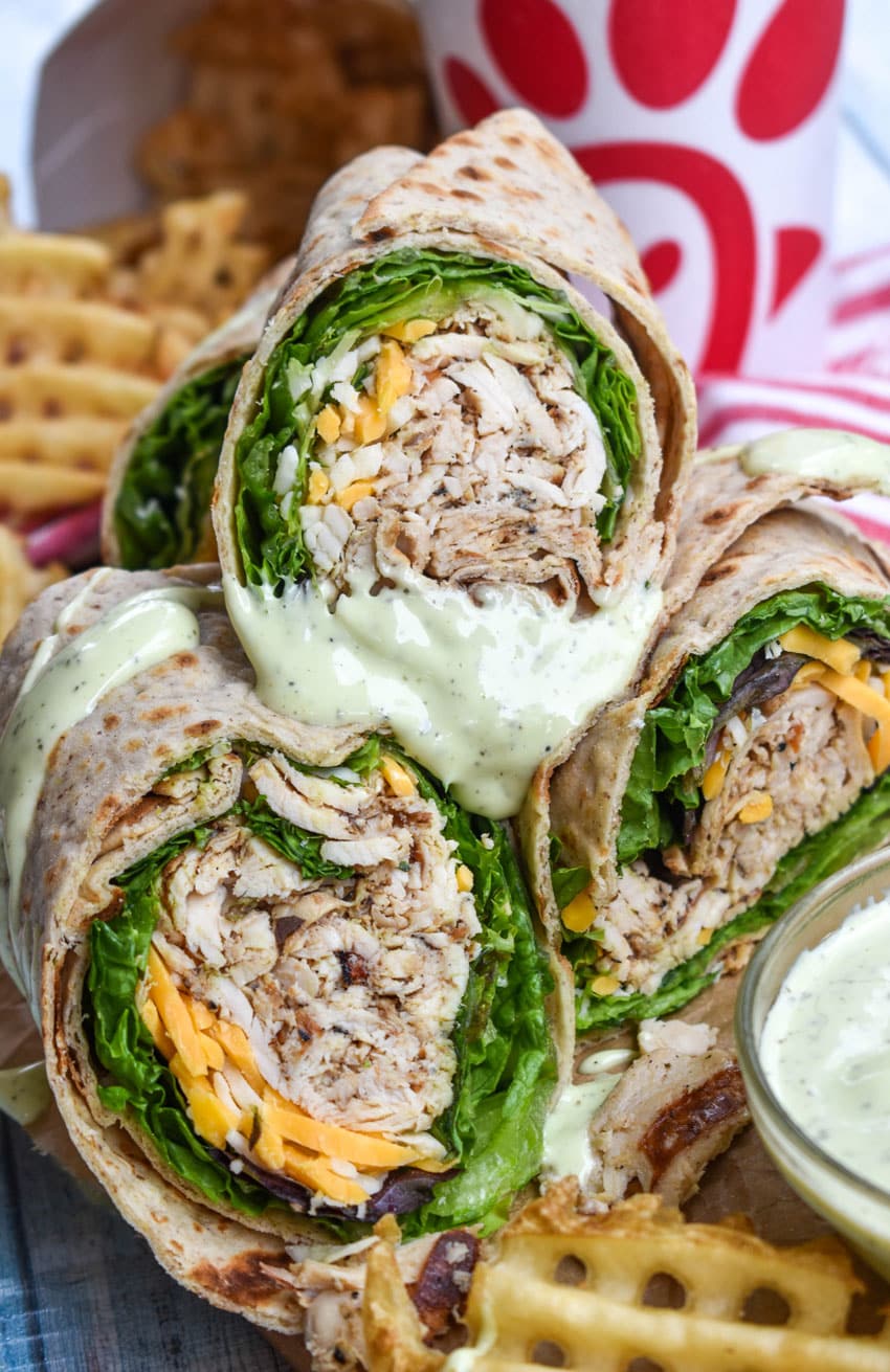 chick fil a chicken cool wraps cut in half and stacked on brown parchment paper