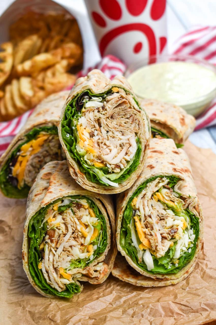 chick fil a chicken cool wraps cut in half and stacked on brown parchment paper