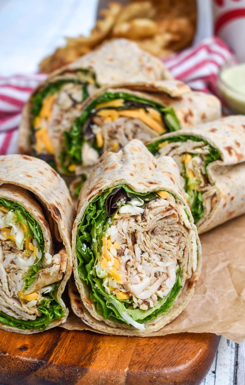 chick fil a chicken cool wraps cut in half and stacked on brown parchment paper